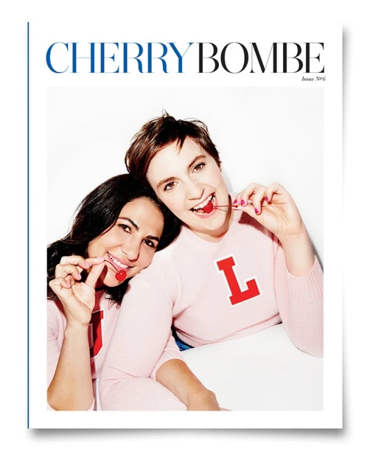 Magazine cover featuring two smiling women in pink sweaters, each holding a cherry, against a bright white background.