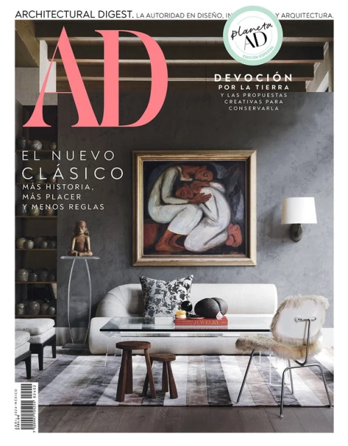 Architectural Digest magazine cover featuring a living room interior with modern furniture and a framed painting of embracing figures.
