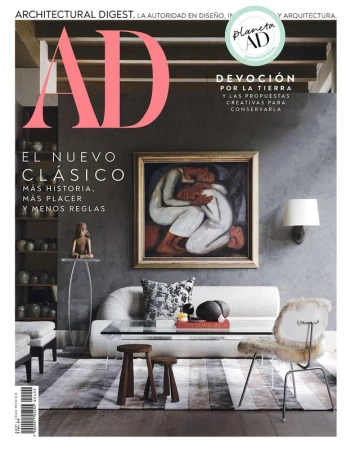 Architectural Digest magazine cover featuring a living room interior with modern furniture and a framed painting of embracing figures.