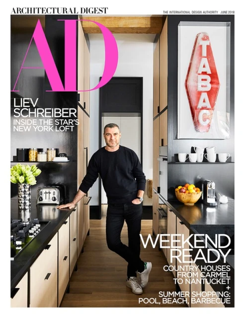 Architectural Digest cover featuring Liev Schreiber in a modern kitchen setting with sleek cabinetry and a black countertop.