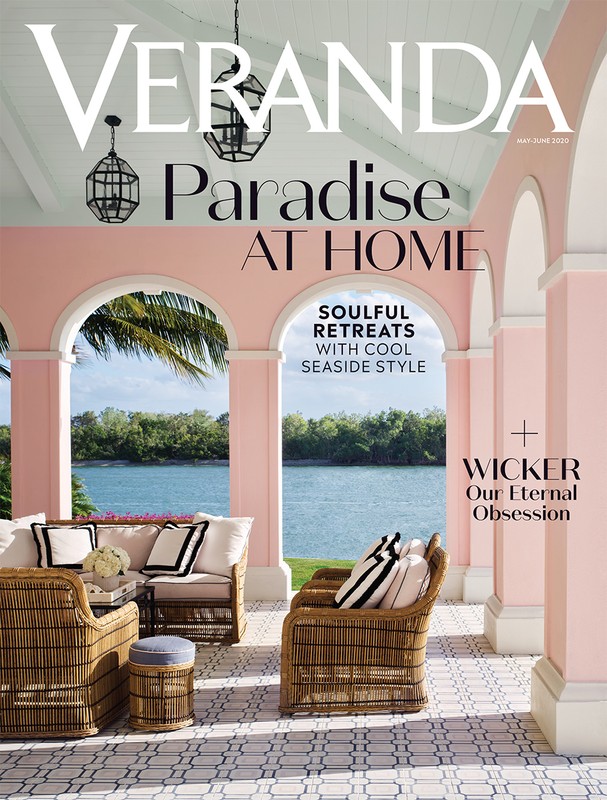 Veranda magazine cover featuring a veranda with wicker furniture and a view of the water through pink arches on a sunny day.