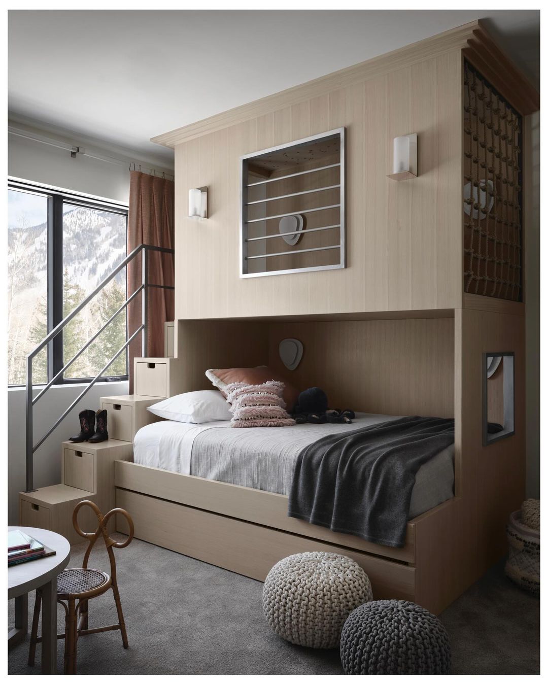 Cozy child's bedroom featuring a custom-built bunk bed with stairs, complemented by natural light and neutral tones, creating a comforting space.