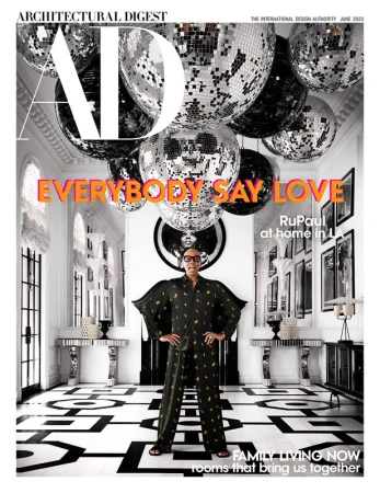 Architectural Digest magazine cover featuring RuPaul in a patterned pajama set, posing in a white interior with disco balls overhead.