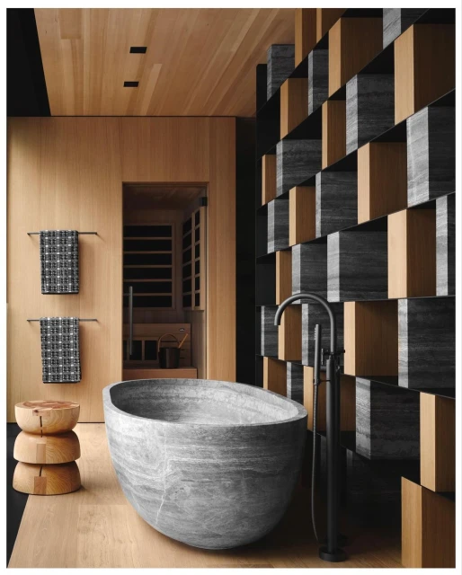 Stone bathtub is the focal point of a modern bathroom with wood paneled walls and floor, and a decorative partition.