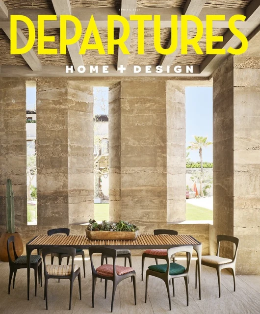Indoor dining area with wooden table, chairs, and minimalist architectural design, featuring magazine cover 'Departures Home + Design'.