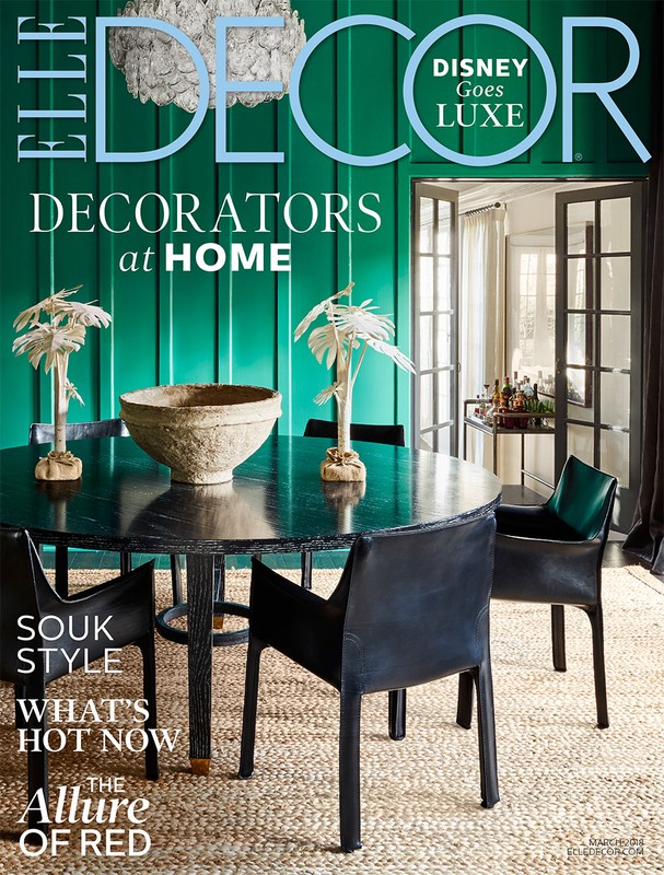Elle Decor magazine cover featuring a dining room with a round table, chairs, a textured bowl, and palm-shaped decor against a green wall.