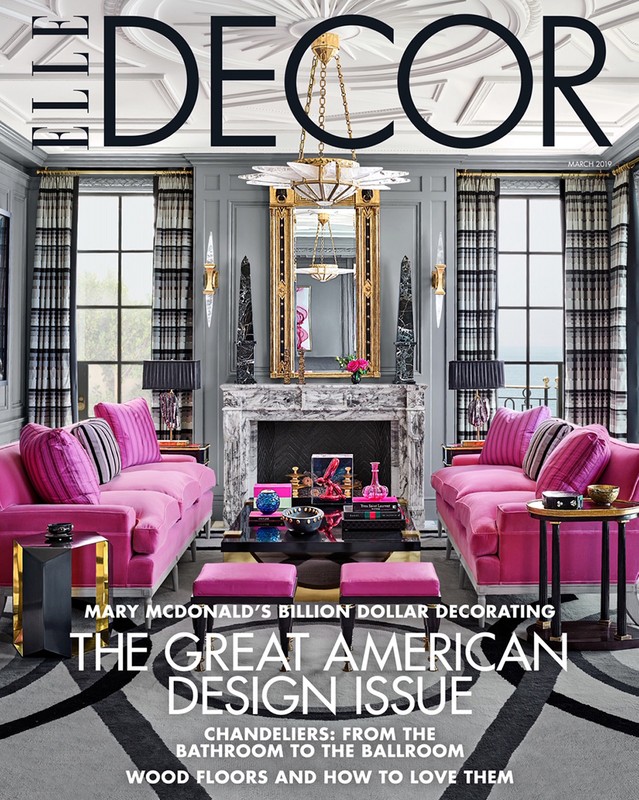 Elle Decor magazine cover featuring a symmetrically styled living room with pink sofas, a marble fireplace, and a chandelier.
