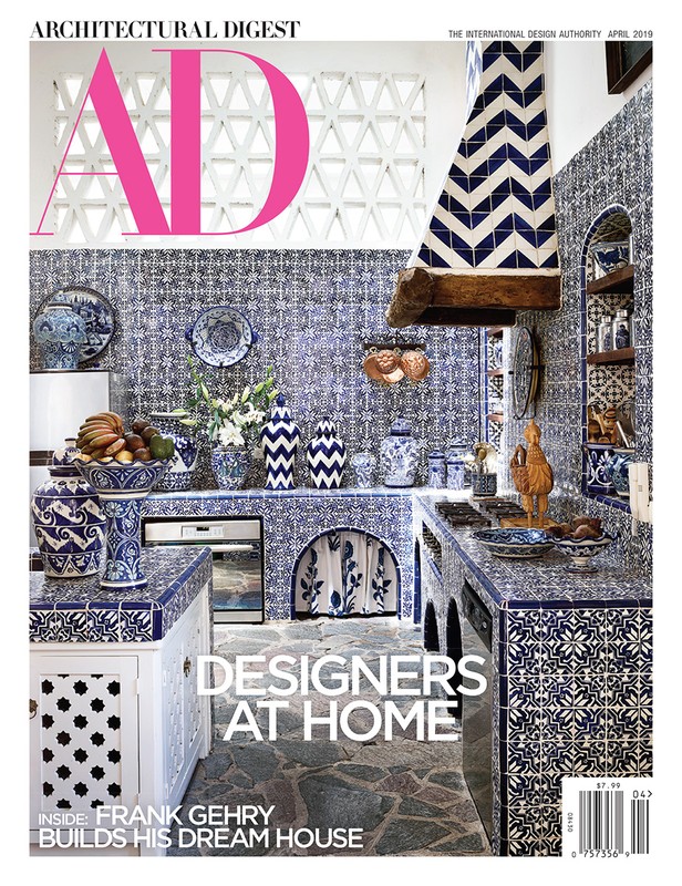 Architectural Digest magazine cover featuring a blue and white tiled kitchen with decorative pottery and fruit, promoting interior design.