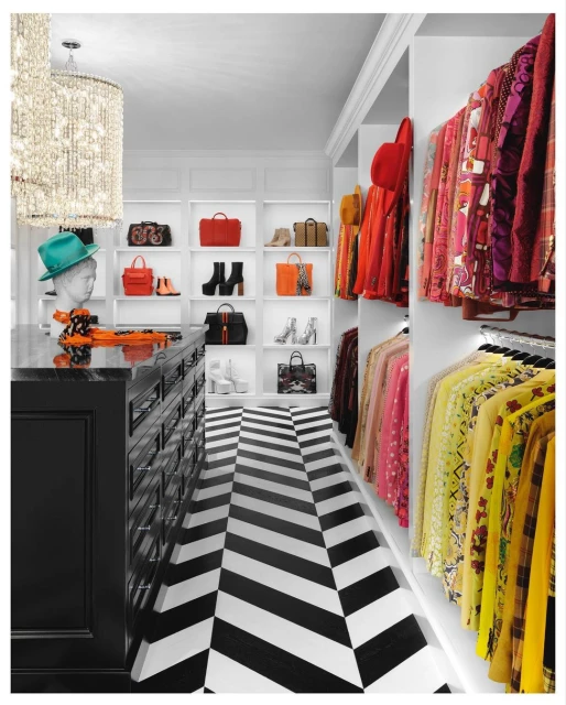 Elegant walk-in closet featuring organized clothes, handbags, shoes displayed on shelves, complemented by a black and white chevron floor.