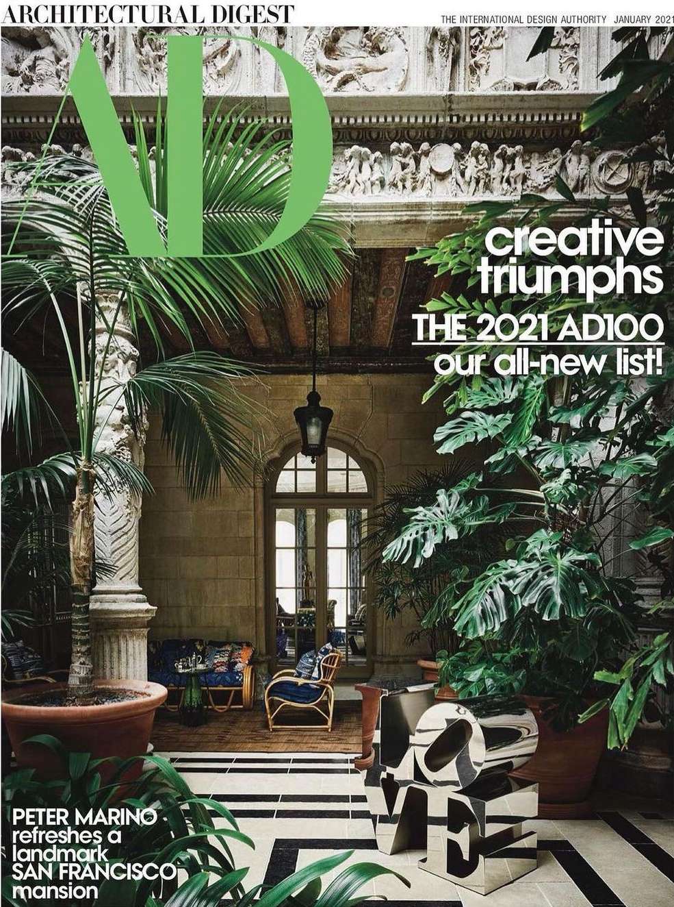 Architectural Digest magazine cover showcasing an indoor courtyard with lush greenery, stone columns, and interior design elements.