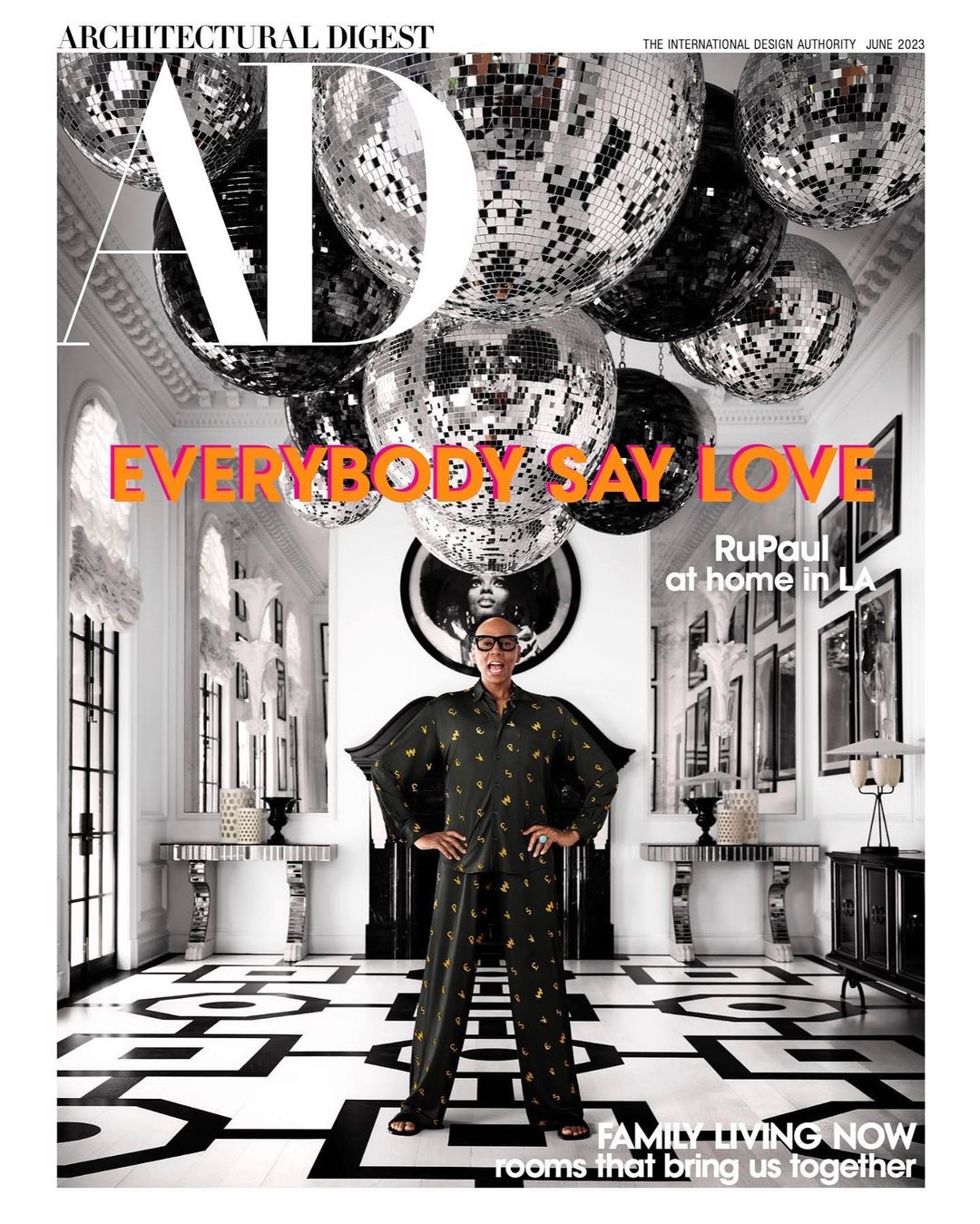 Architectural Digest cover featuring RuPaul in patterned pajamas, standing in a black and white patterned room with disco balls hanging from the ceiling.