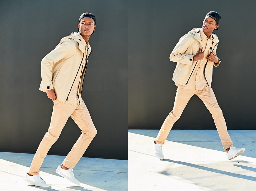 A young Black man in a beige jacket and pants walks against a grey wall in a split image with varied poses in a fashion context.