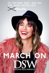 Smiling woman wearing a black wide-brim hat and pink faux-fur coat against a grey gradient background