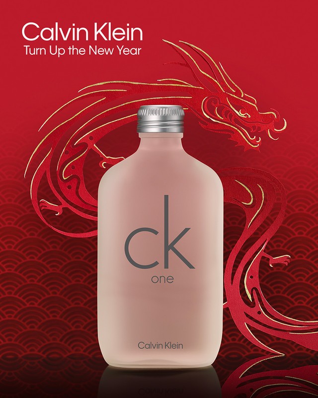 Calvin Klein CK One fragrance bottle on a red background with gold dragon illustration for the new year. Beauty and product photography.