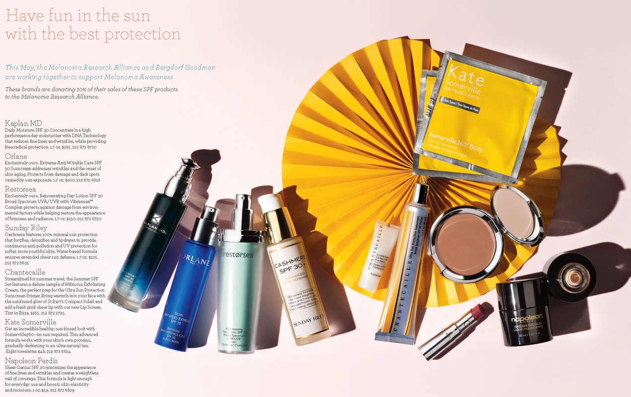 Collection of skincare and makeup products from various brands arranged against a backdrop of yellow paper decorations and a pink background.
