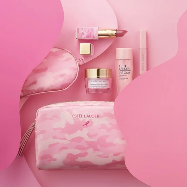 Estee Lauder cosmetics flat lay with camouflage-patterned bags, lipstick, and skincare products on a pink, layered background.