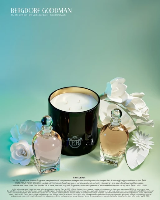 Still life of perfume bottles, a candle in a black container, and paper flower decorations, creating an elegant and fragrant composition.