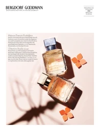 Two glass perfume bottles on a pale pink surface with orange paper flower cutouts styled by Eloise Corr Danch in New York