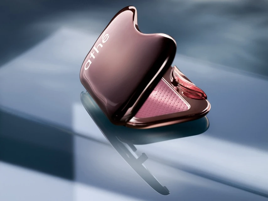 Rose-gold compact with blush, angled view on blue backdrop. Minimal product shot for beauty, luxury, and cosmetics industries.