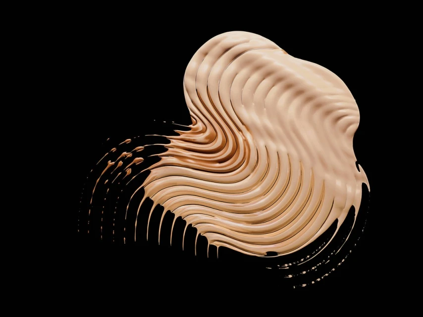 Beige foundation swatch on a black background with wavy texture and smooth, glossy surface in beauty and cosmetic context.