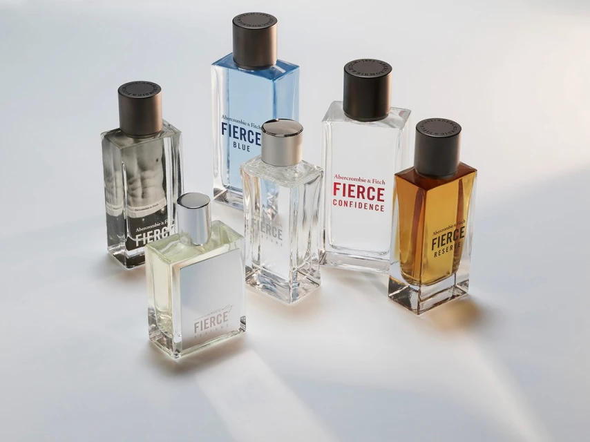 Six Abercrombie & Fitch 'Fierce' cologne bottles in clear glass and various scents are arranged on a light surface, creating a modern still life.
