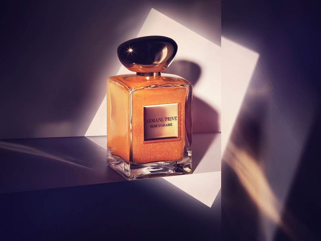 Armani Prive Rose D'arabie perfume bottle on a white surface with geometric shapes in the background and soft, diffused lighting.