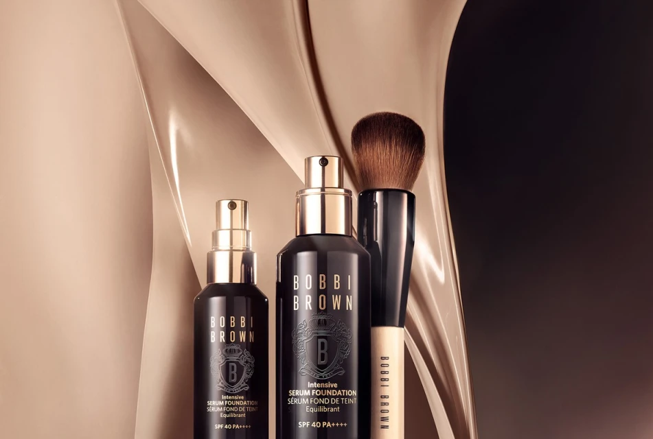 Bobbi Brown Intensive Serum Foundation and makeup brush in a studio setting with soft, neutral lighting and elegant product presentation.
