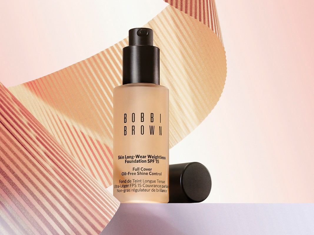 Bobbi Brown Skin Long-Wear Weightless Foundation SPF 15 product shot on a white surface with peach-toned striped background.