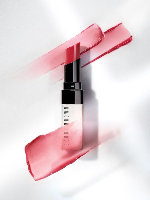 Bobbi Brown lipstick on a white surface with smears of lipstick forming a backdrop in an overhead studio shot.