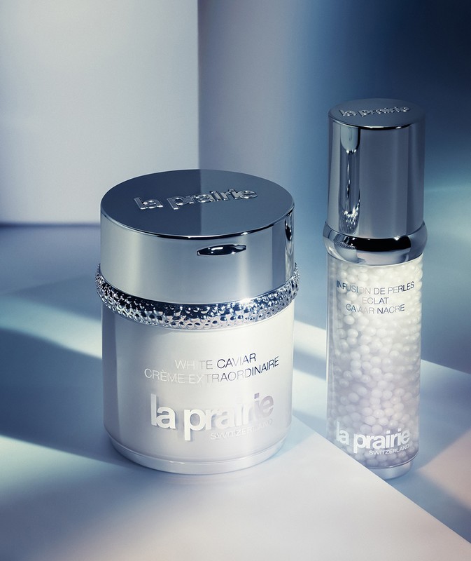 Close-up of La Prairie skincare products: a white cream jar and a clear bottle with pearls, showcasing luxury beauty and skincare.