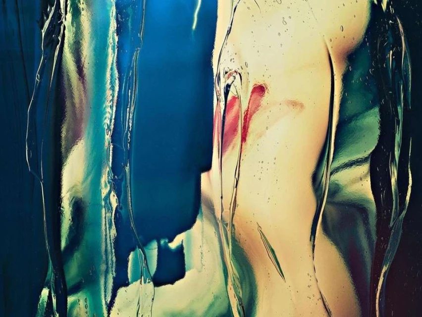Abstract art featuring a blurred female figure with a bright red lip, distorted by a transparent layer of reflective rippled glass.