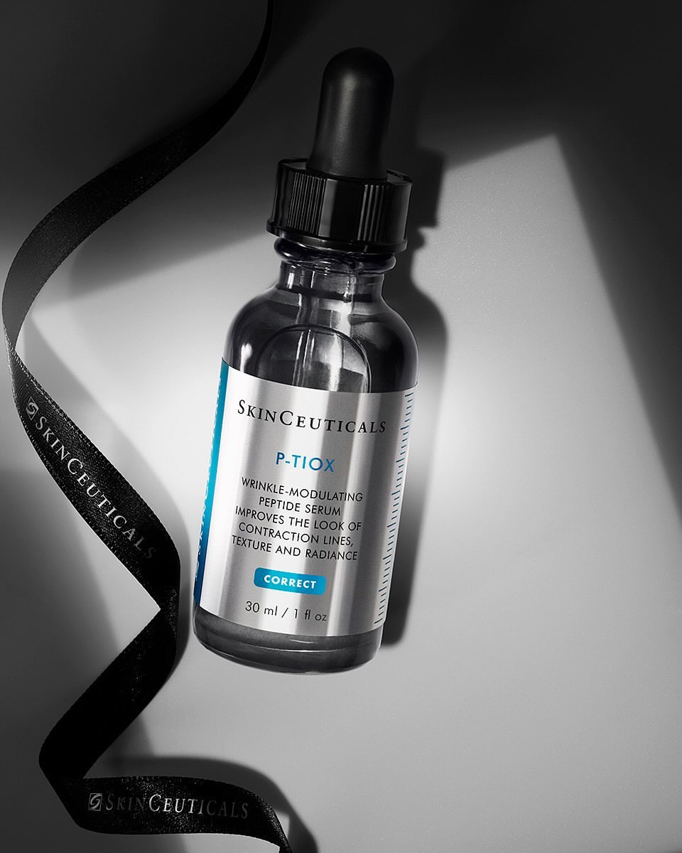 Cosmetic bottle of SkinCeuticals P-Tiox wrinkle-modulating peptide serum with dropper, product label, and black ribbon accent.