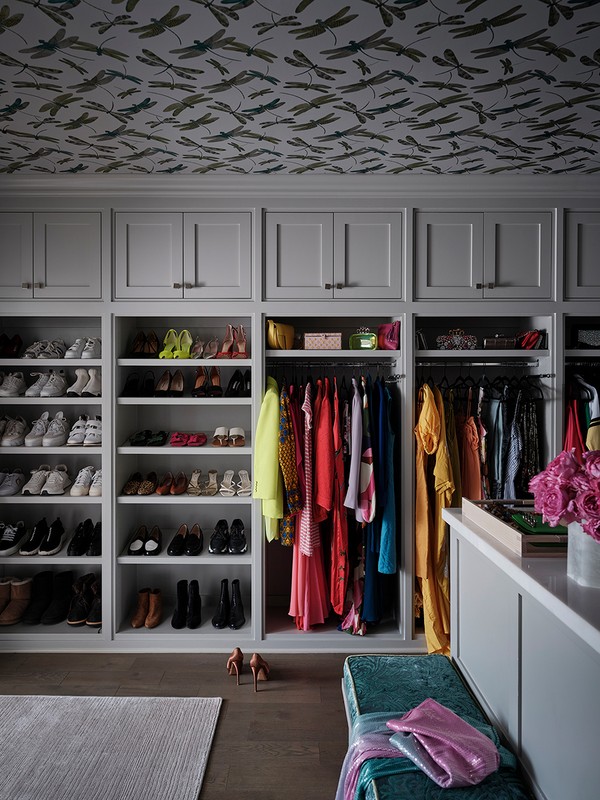 Bright, well-organized walk-in closet with custom shelving for shoes and clothes. A stylish storage space for fashion apparel.