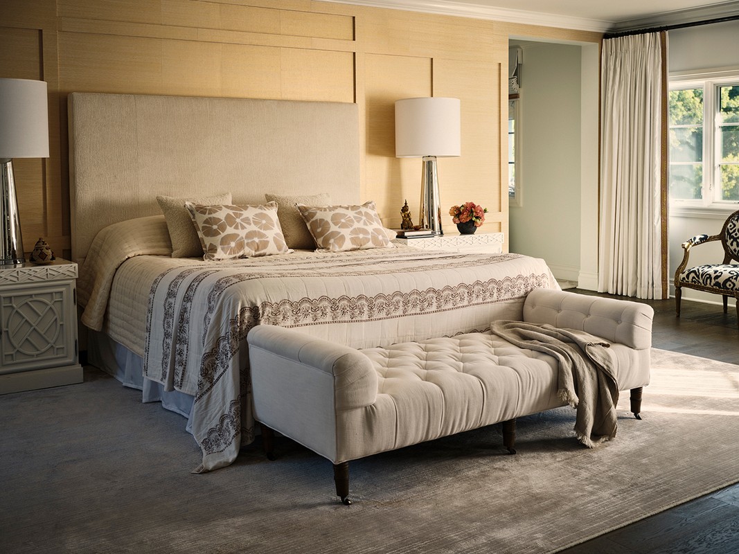 Tranquil interior featuring a comfortable bedroom with neutral tones, patterned textiles, and a luxurious upholstered bench.