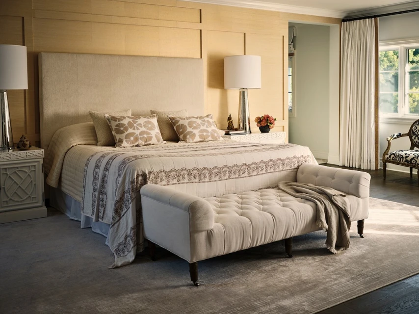 Tranquil interior featuring a comfortable bedroom with neutral tones, patterned textiles, and a luxurious upholstered bench.