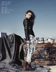 Model with dark hair wearing a black leather jacket and distressed jeans on a rooftop by Fredy Anaya