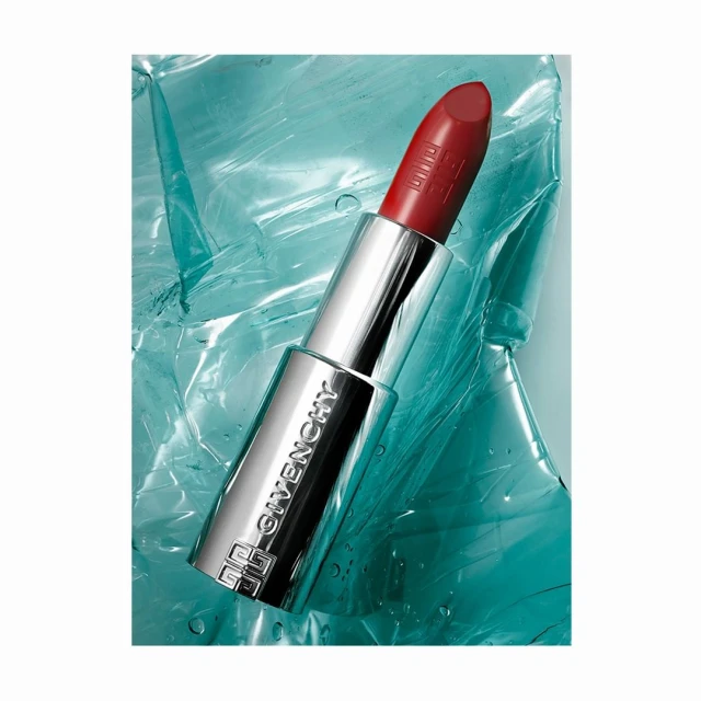 Close-up of a silver Givenchy lipstick tube with a red lipstick bullet, against a textured translucent blue background.