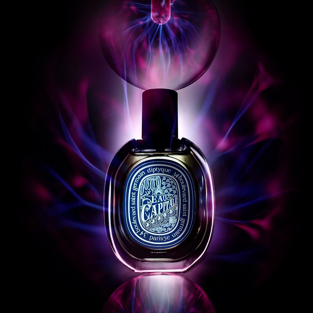 Elegant perfume bottle with abstract blue and purple lighting effects on a glossy black surface, studio shot, showcasing luxury and fragrance.