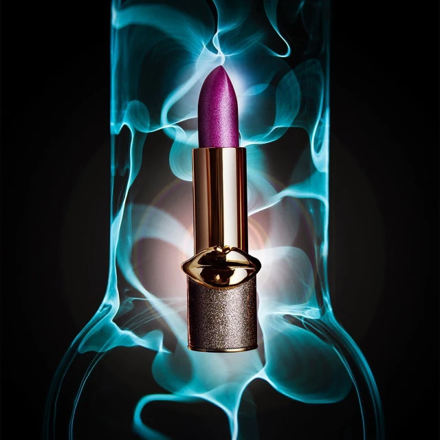 Close-up shot of a purple lipstick tube in front of blurred blue and white background, product shot for beauty or cosmetic.