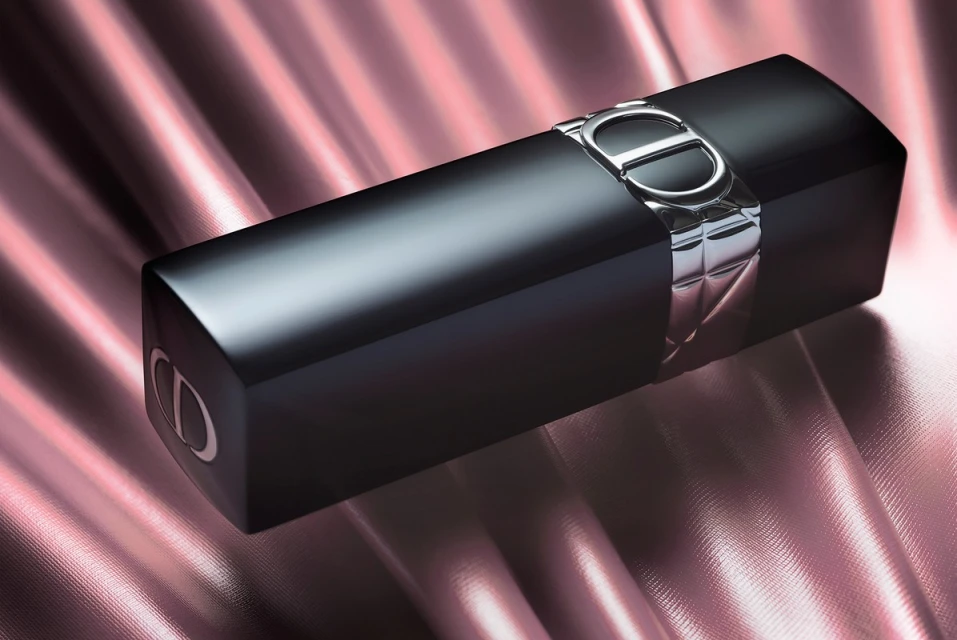Elegant black lipstick with silver accents on a satin pink background, close-up product shot for beauty and cosmetic advertising.