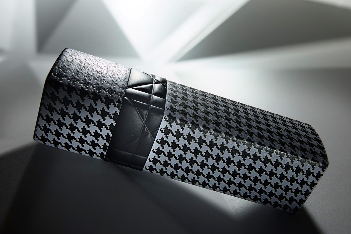 Houndstooth patterned product box with black quilted top detail against a white and gray gradient background, angled light and shadows.