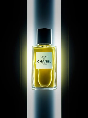 Chanel perfume bottle on a vertical illuminated column against a stark dark background, photographed by Graeme Montgomery.