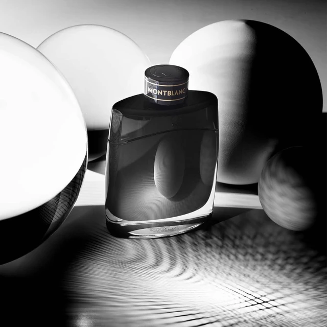 Montblanc Legend fragrance bottle in black and white, studio shot with spherical forms, product photography, men's cologne, close-up.