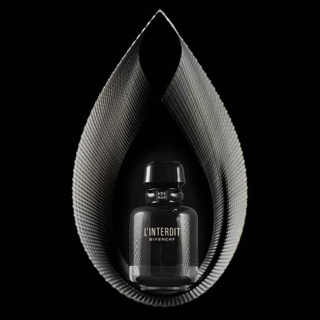 Elegant studio shot of a 'L'Interdit Givenchy' perfume bottle encased by a teardrop-shaped, metallic fabric structure on a black backdrop.