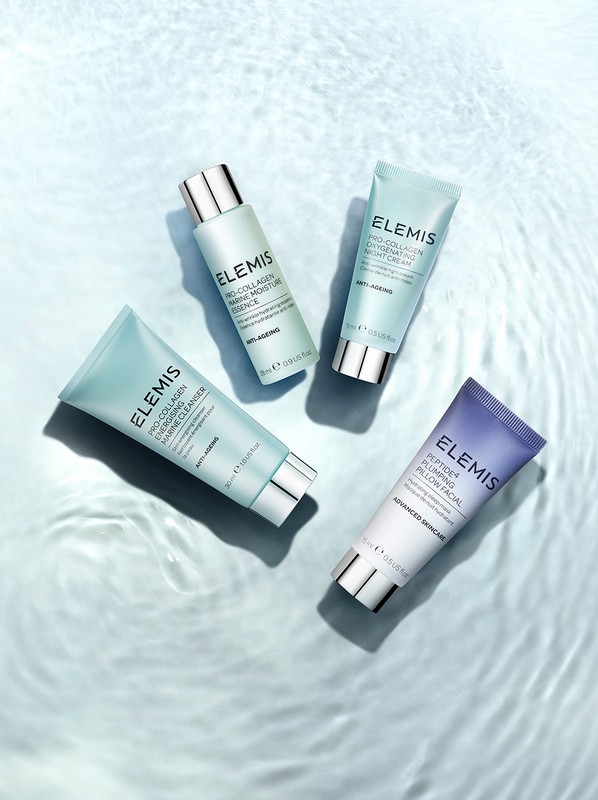 Four Elemis skincare products arranged on a light blue rippled water surface, showcasing their packaging and design.