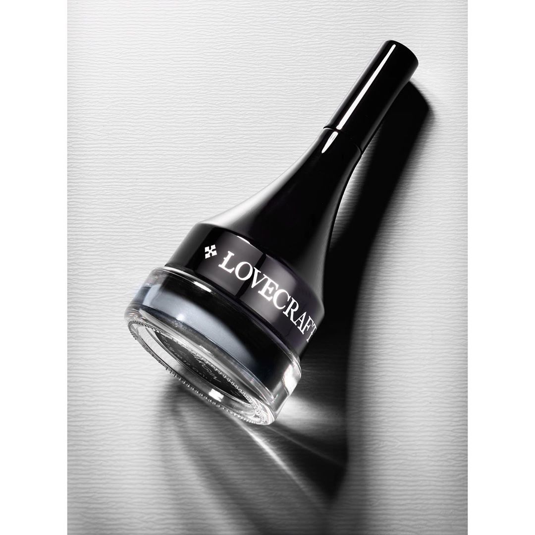 Close-up studio shot of a glass jar of black gel eyeliner with the brand name Lovecraft in white letters against a light gray background.