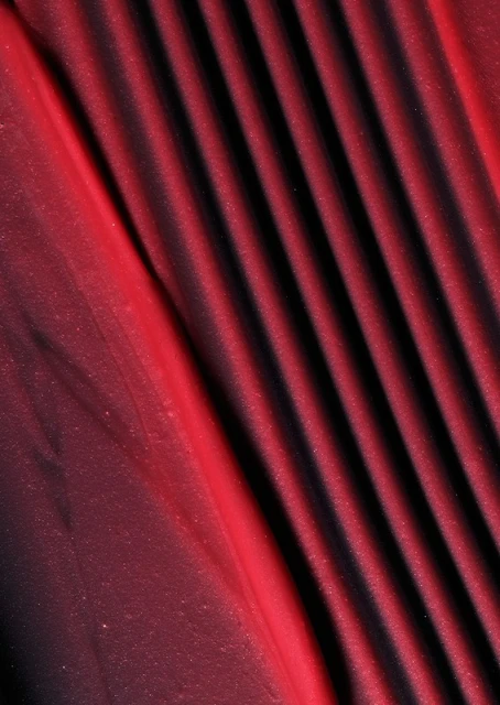Burgundy textile fabric with diagonal pleats and a silky shimmer.