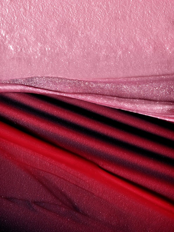 Abstract macro shot of pink and red fabric with diagonal stripes. Soft, textured, and elegant, showcasing textile detail and color gradient.