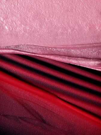 Abstract macro shot of pink and red fabric with diagonal stripes. Soft, textured, and elegant, showcasing textile detail and color gradient.