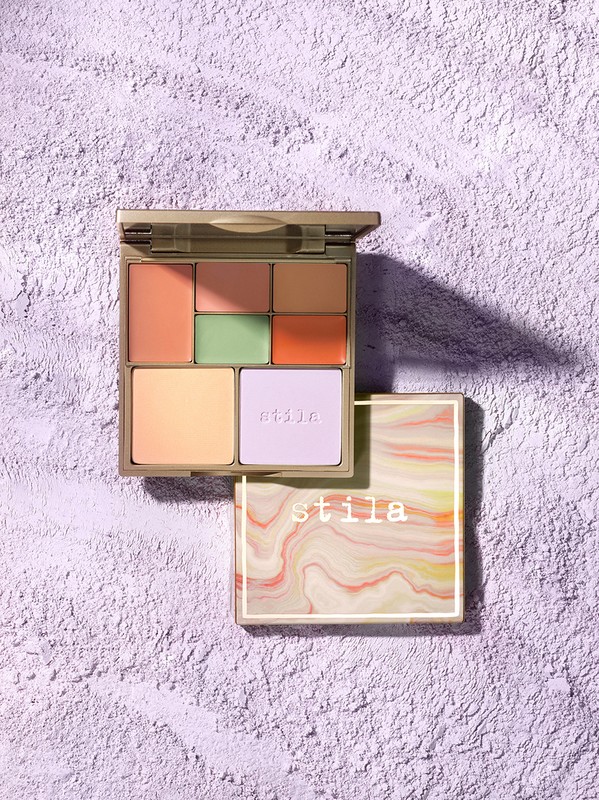 Stila Correct & Perfect Palette with multiple shades for color correction and concealing on textured lavender background, close-up.